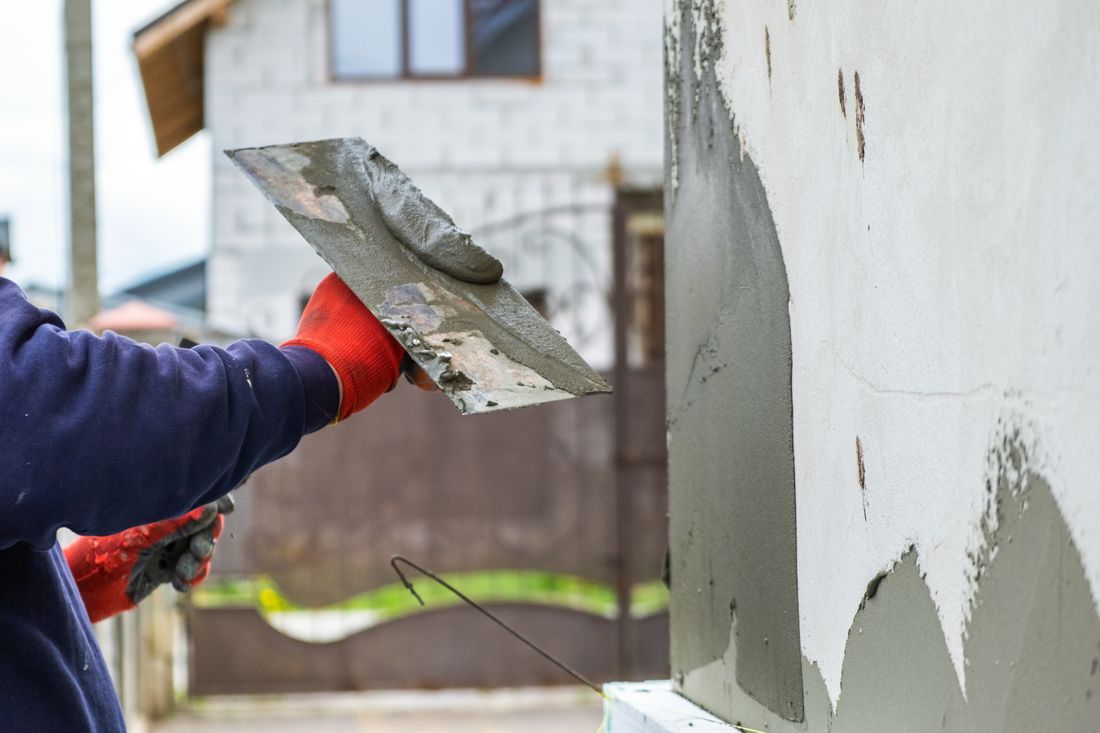 Smoothing fresh stucco on an exterior wall in Anderson, IN